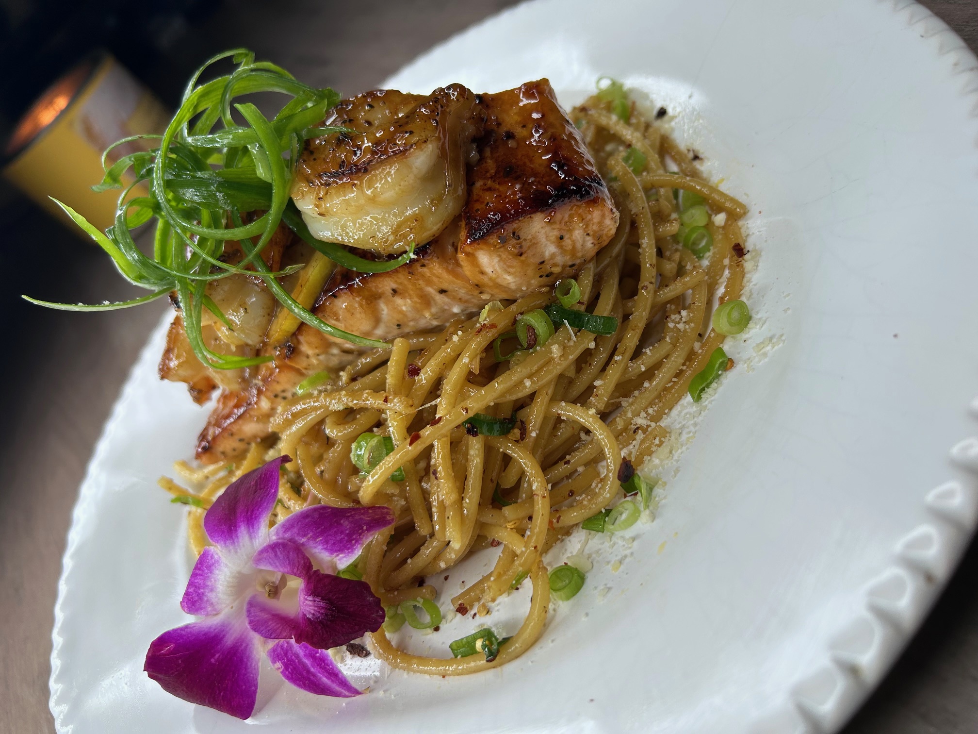 Broiled salmon over garlic noodles